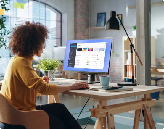 Image d'une personne utilisant un ordinateur dans un bureau pour représenter un environnement de travail sécurisé.